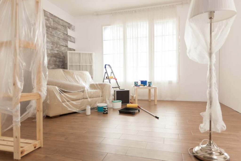 Apartment with nobody in it ready for professional renovation. Plastic sheet. Home during renovation, decoration and painting. Interior apartment improvement maintenance. Roller, ladder for house repair